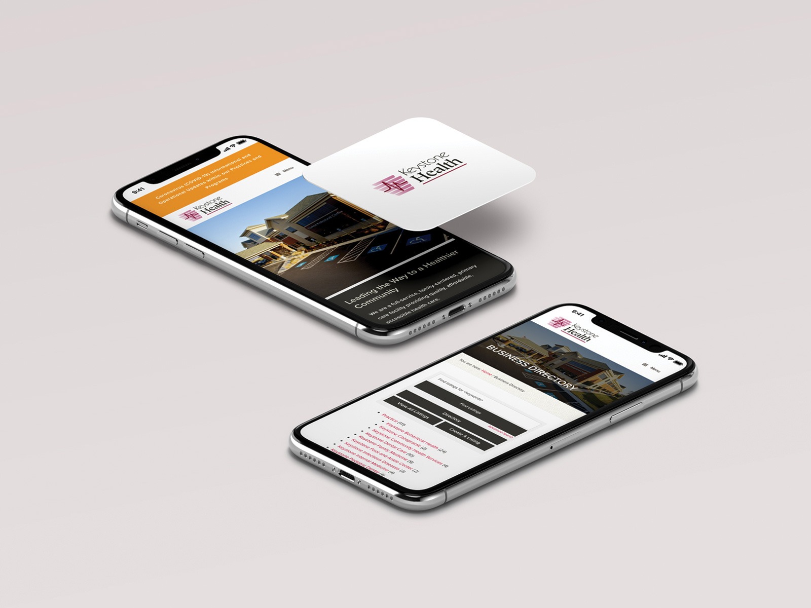 Two smartphones display a real estate website with a focus on property listings and contact information. A business card with the logo